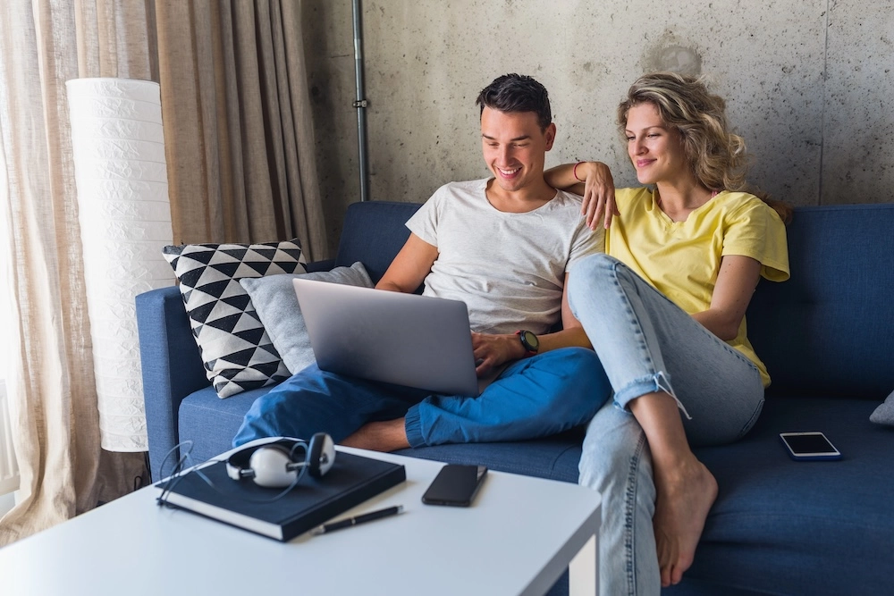 Cuplu căutând apartamente pe laptop